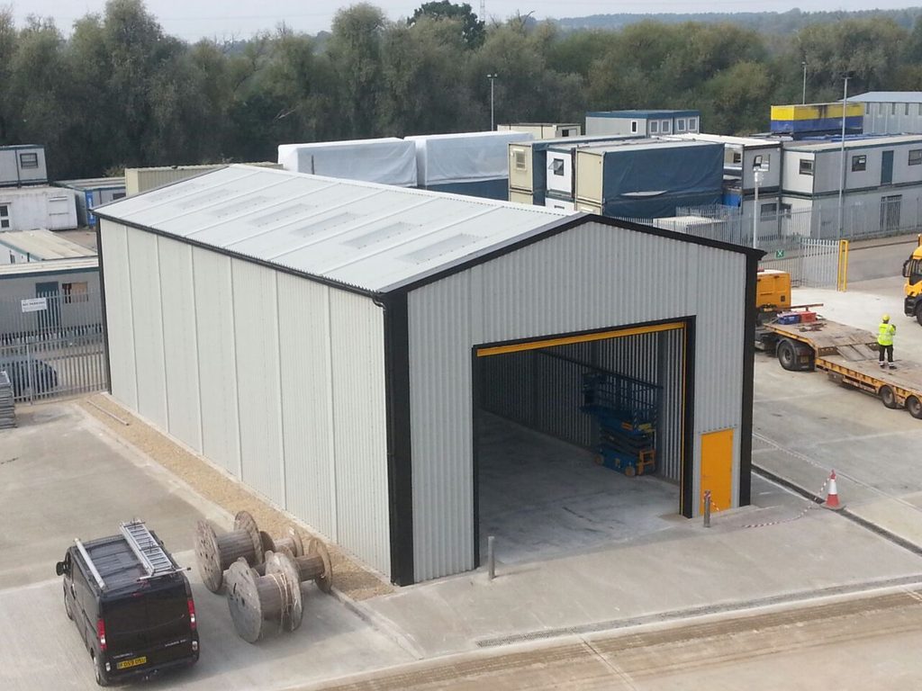 Industrial steel building with grey cladding and large roller shutter access door.