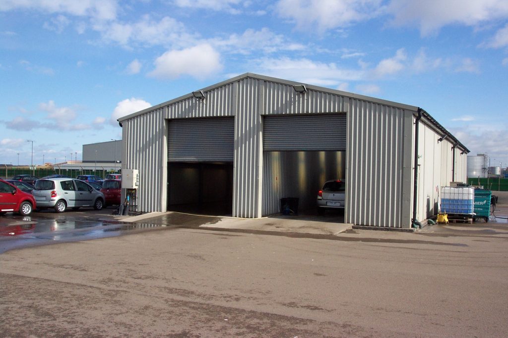 Vehicle maintenance building for On-Time with two large roller shutter doors and vehicle workshop bays. Building divided into spaces.