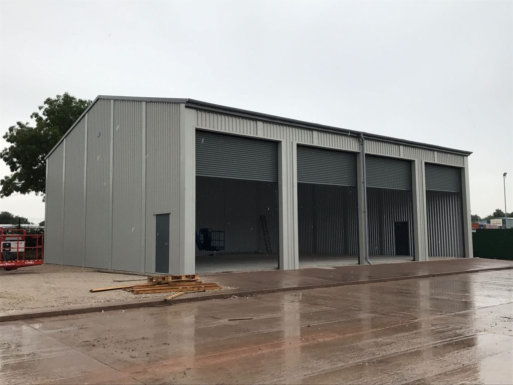 Industrial Steel Storage Building with four large access roller shutters in side elevation for Tippers, Britannia Way.