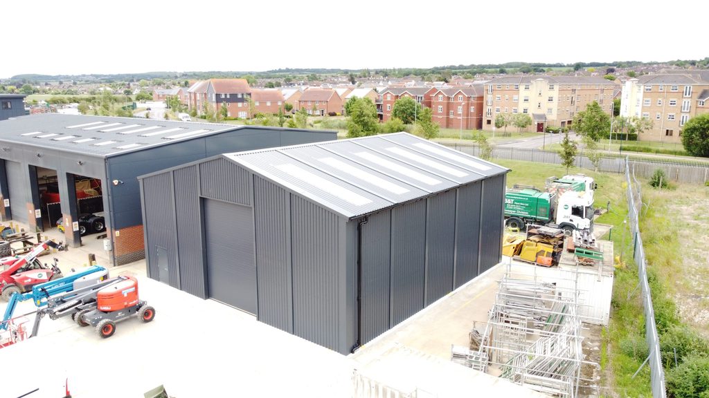 Aerial view of prefabricated steel storage building for B & T Plant, featuring grey cladding and pitch roof and gable end access door.