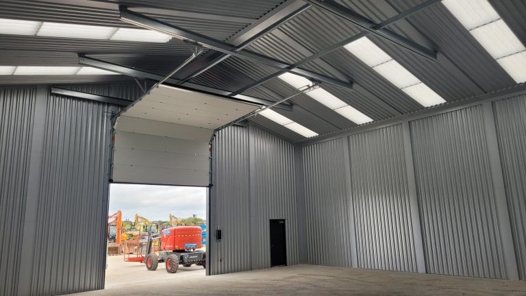 Internal photo of B & T Plant Hire showing internal roof steelwork and folding sliding shutter door.