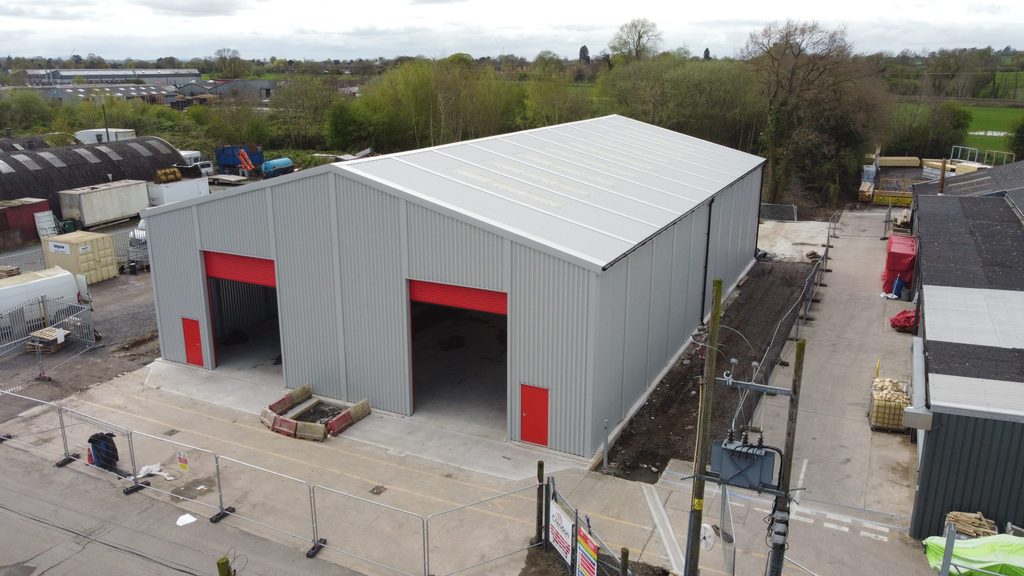 Large steel prefabricated modular steel building with two large roller shutters in the gable elevation for Crendan Timber in Wem, Shropshire.