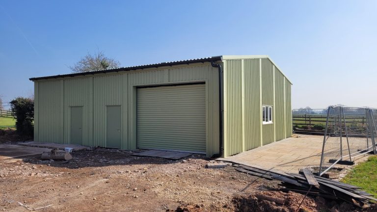 Prefabricated steel storage building with roller shutter door and personnel doors and windows for Priory Farm.