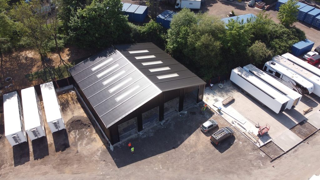 Aerial view of prefabricates steel trailer maintenance workshop for Tommy Traylen, featuring large vehicle access bays and rooflights.